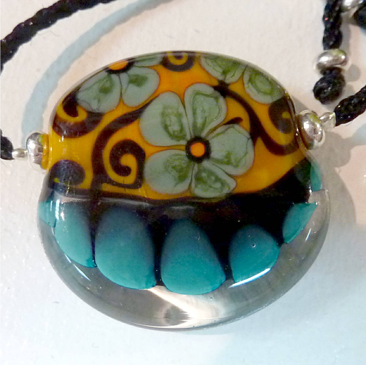 perle plate décorée montée en collier
